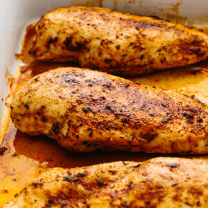 Oven baked chicken breasts in a casserole pan.