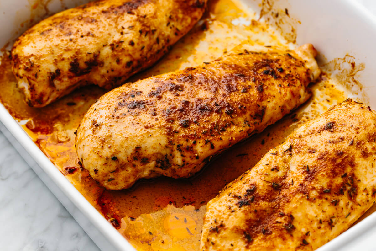 Baked chicken breasts in a pan on a table.