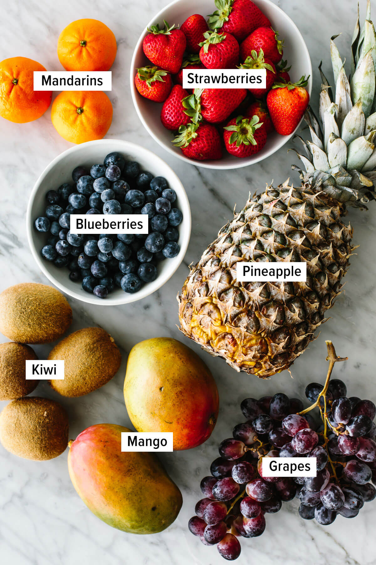 Ingredients for a classic fruit salad on a table.