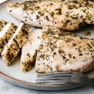 A plate of herb baked chicken breast slices.