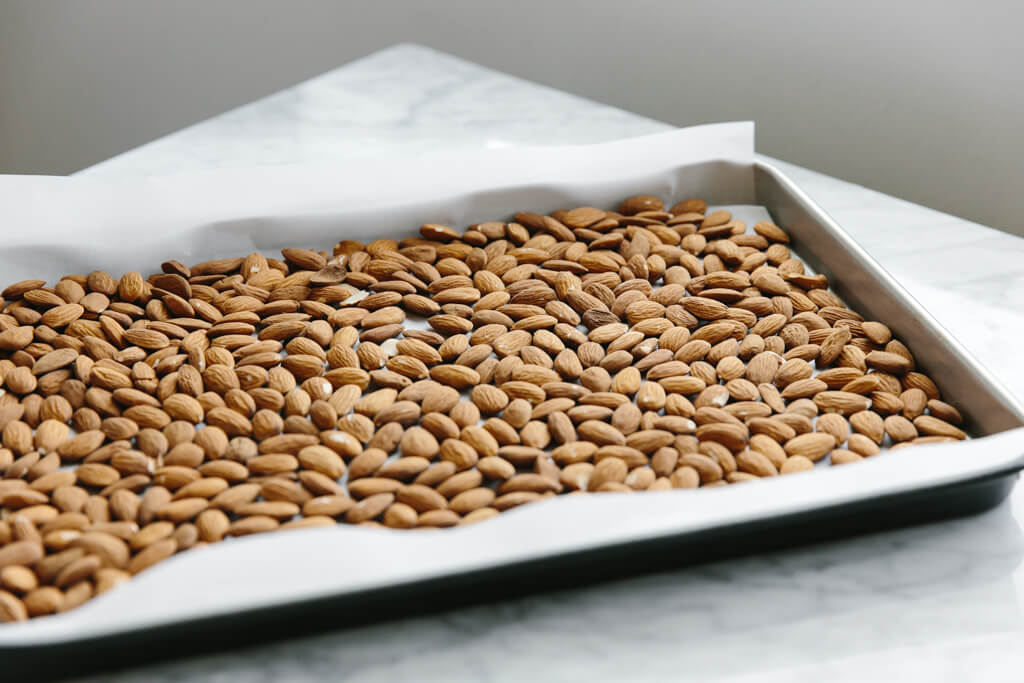 Raw almonds on a baking sheet.