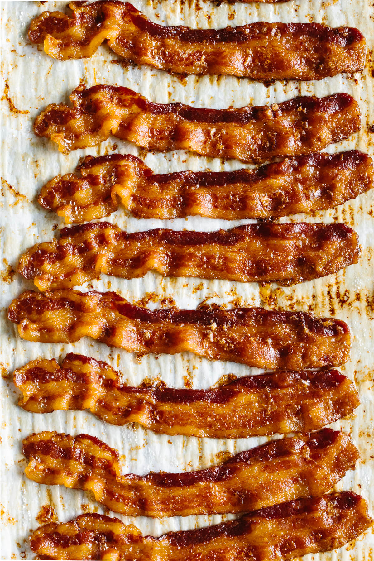Slices of cooked bacon on a sheet tray.