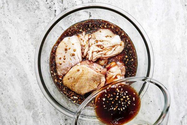 Mixing chicken thighs with balsamic marinade