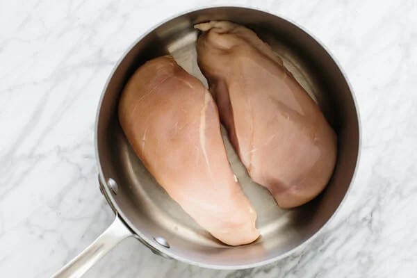Two chicken breasts in a pot.