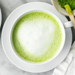 A cup of matcha latte next to a napkin