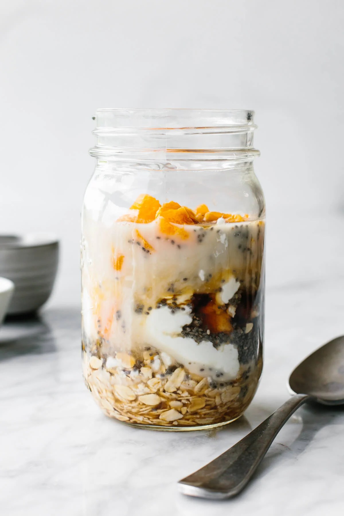 Adding orange creamsicle overnight oats ingredients into a jar