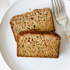 Two slices of paleo zucchini bread on a white plate.