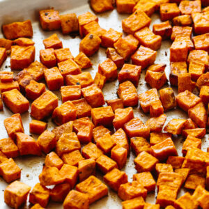 Roasted sweet potatoes on a sheet tray.