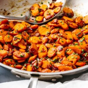 A large pan of sauteed carrots with bacon Dijon dressing