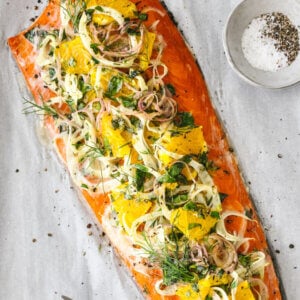 Slow roasted salmon with fennel and orange and herbs next to a fork.