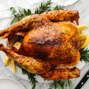 Thanksgiving turkey on a plate with sage and lemons.