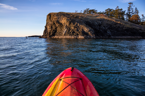 A serene nature photograph taken at Deception Pass, showcasing the natural beauty of the water from a kayak